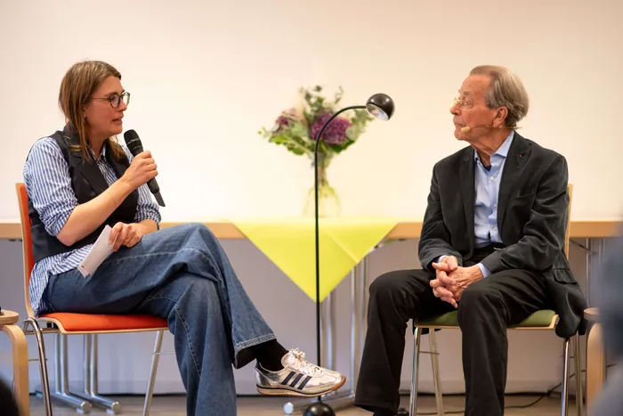 Ina Blumenthal spricht mit einem Mikrofon zu Franz Müntefering, der ihr zuhört.