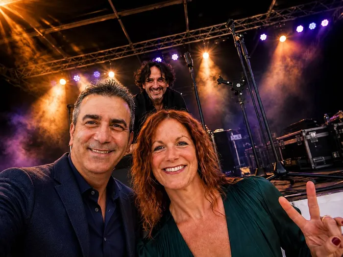 Salvatore Bucco, Desirée Bucco und Daniele Bucco lächeln auf einer hell beleuchteten Bühne mit Musik-Equipment im Hintergrund.