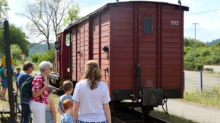 Zuschauer betrachten einen historischen Güterwagen mit der Nummer 392 der Sauerländer Kleinbahn.