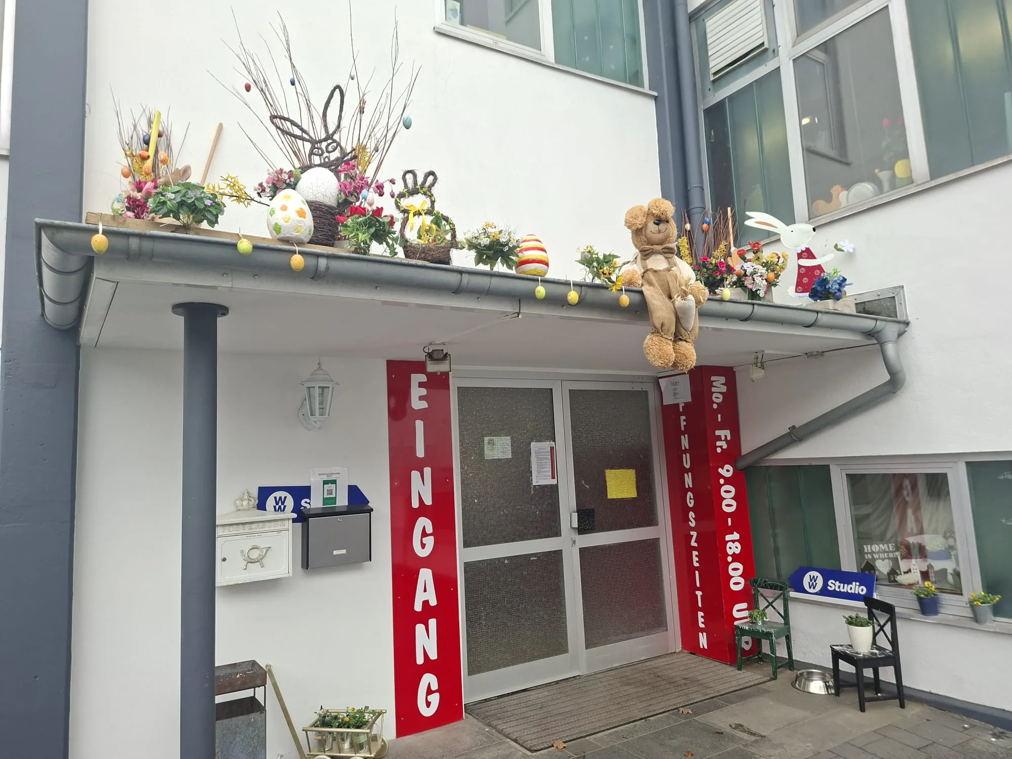 Der Eingangsbereich des Werkhofs ist mit Ostereiern, Hasen und Lichterketten dekoriert. Über dem Eingang steht in großen roten Buchstaben „EINGANG“.