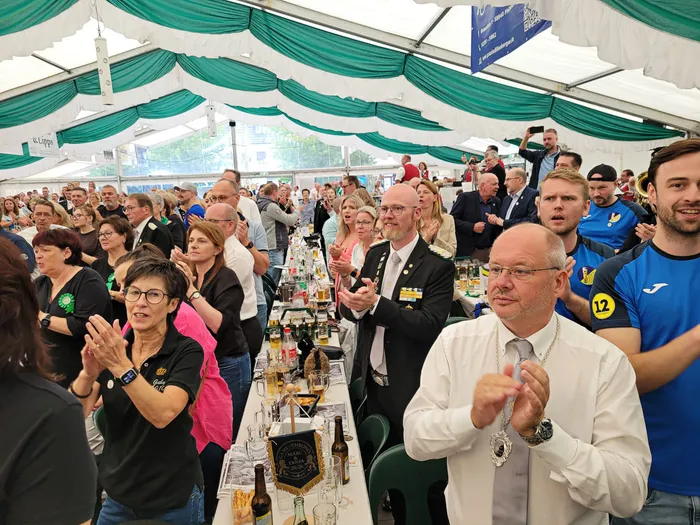 Zuschauer klatschen in einem Festzelt während einer Veranstaltung des Schützenvereins.