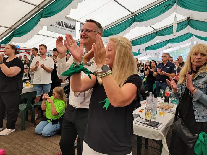 Menschen klatschen und feiern in einem grün geschmückten Festzelt während des Schützenfestes in Eiringhausen.