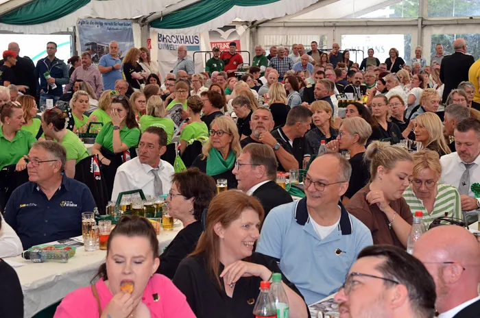 Eine große Menschenmenge sitzt an Tischen in einem gut besuchten Festzelt während des Schützenfests.