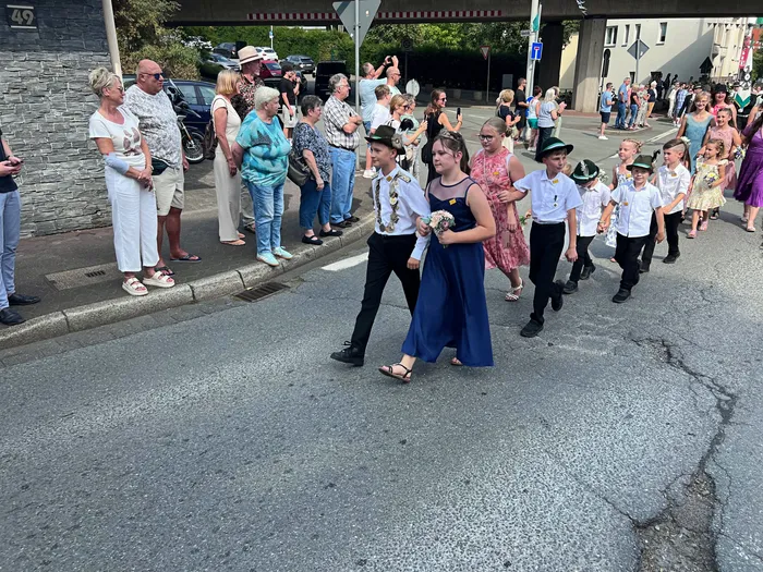 Kinder in festlicher Kleidung ziehen bei einem Schützenfest-Umzug in Eiringhausen an Zuschauern am Straßenrand vorbei.