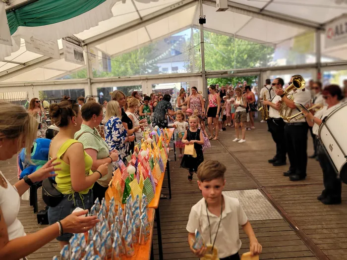 Menschen und Kinder versammeln sich unter einem Festzelt beim Schützenfest Eiringhausen, während eine Blaskapelle spielt.