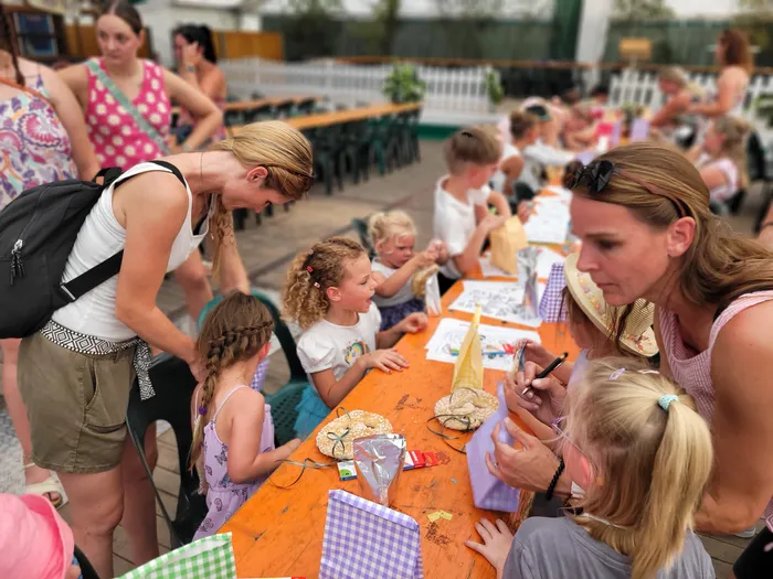 Kinder basteln und malen an einem langen orangefarbenen Tisch während des Kids Day beim Schützenfest Eiringhausen.