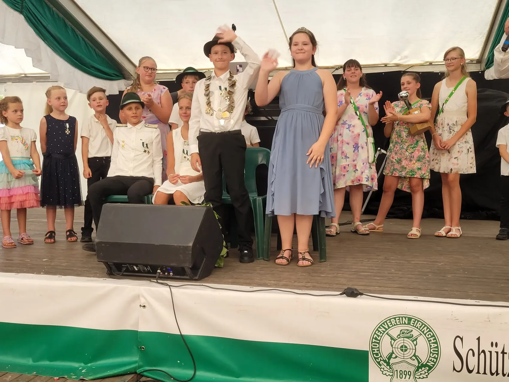 Kinder bei der Kinderkrönung auf dem Schützenfest Eiringhausen; ein Junge mit Medaillen und Hut sowie ein Mädchen in einem blauen Kleid winken.