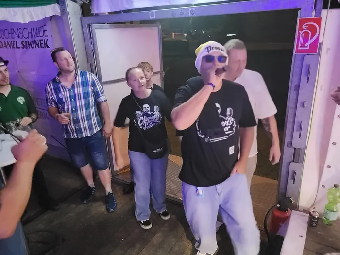 Clemens Werner tritt mit einem Mikrofon in einem Festzelt auf.