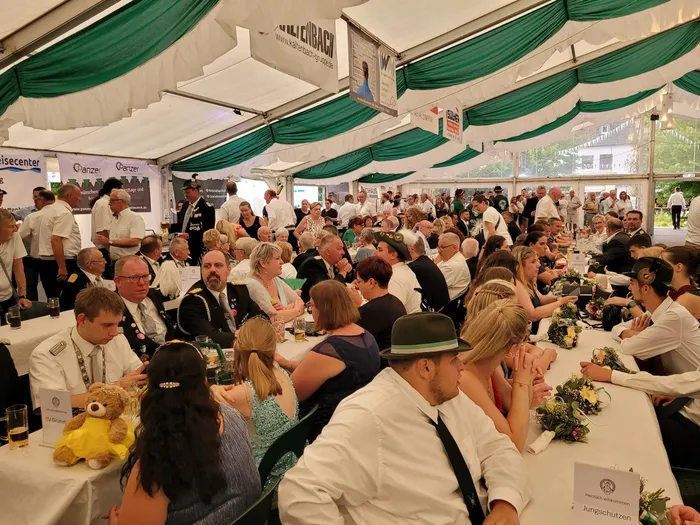 Viele Gäste sitzen an langen Tischen in einem großen Festzelt während des Krönungsabends des Schützenvereins Eiringhausen.