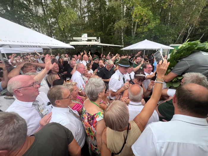 Eine jubelnde Menschenmenge mit erhobenen Händen feiert das Königsvogelschießen beim Schützenfest in Eiringhausen.