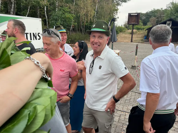 Sascha Kasel lächelt in einem weißen Poloshirt und einem grünen Hut beim Schützenfest Eiringhausen.
