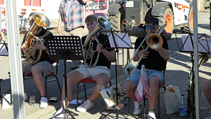 Drei Musiker der Kompanie Ohle spielen im Freien Blasinstrumente wie Tuba und Posaune.