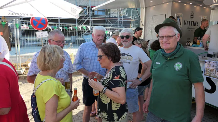 Menschen unterhalten sich bei Getränken im Freien während eines Schützenfest-Warm-ups der Kompanie Ohle.