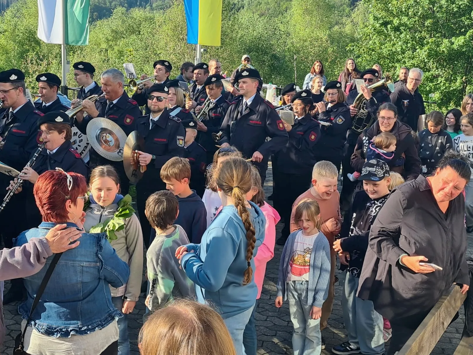 Musikzug der Freiwilligen Feuerwehr spielt vor einer Gruppe von Kindern und Erwachsenen auf dem Schützenfest im Grünetal.