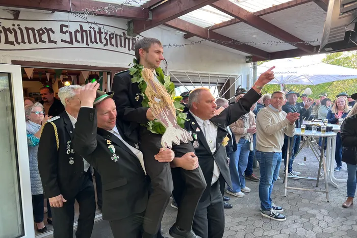 Christian Hoffmann wird nach dem Gewinn des Vogelschießens vom Schützenverein Grünetal gefeiert, um seinen Hals trägt er einen grünen Kranz.