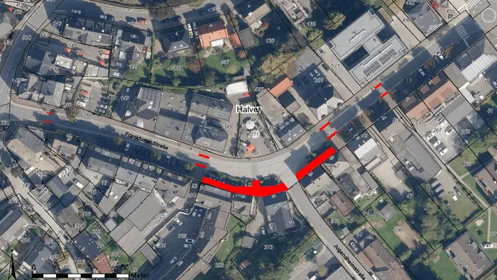 Ein Luftbild zeigt die Frankfurter Straße in Halver, wobei eine rote Linie den Verlauf der Asphaltfläche markiert. Die Straße biegt sich in einem weiten Bogen und wird von Wohngebäuden gesäumt.