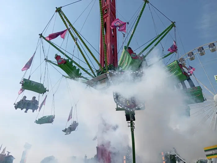 Ein Karussell namens „SkySwing“ mit schwingenden Gondeln und Dampf, der aus den Düsen aufsteigt, steht auf der Kirmes.