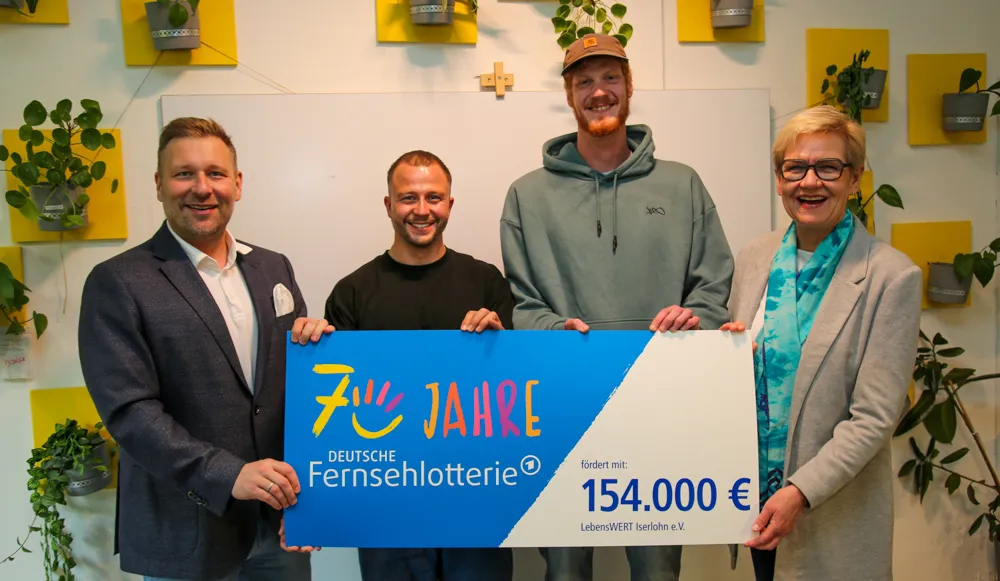 Vier Personen posieren mit einem Scheck der Deutschen Fernsehlotterie über 154.000 Euro für LebensWERT Isertohn e.V. 