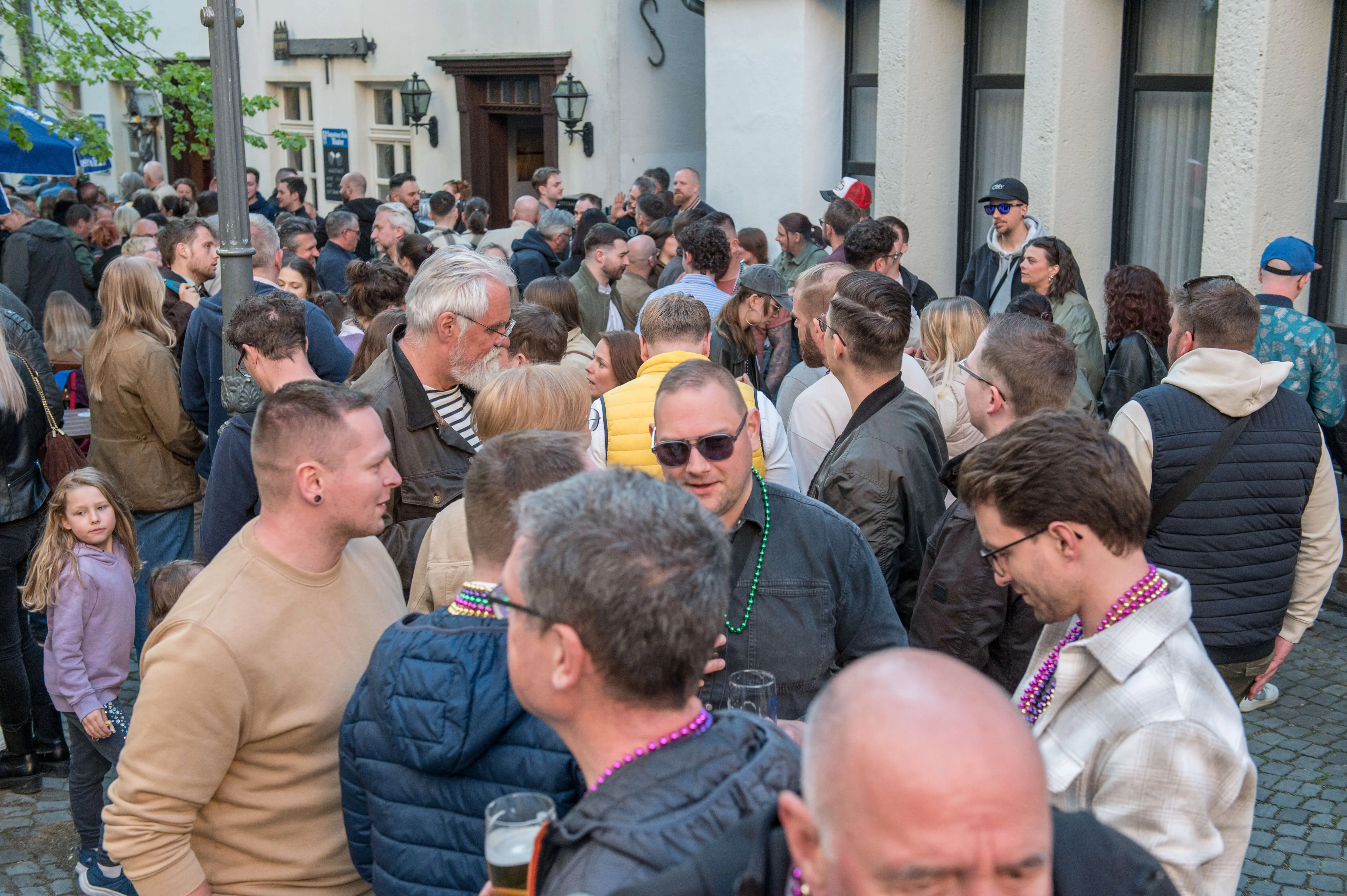 Große Menschenmenge auf einer belebten Straße vor Kneipen und Restaurants während der Thekentour in Lüdenscheid.