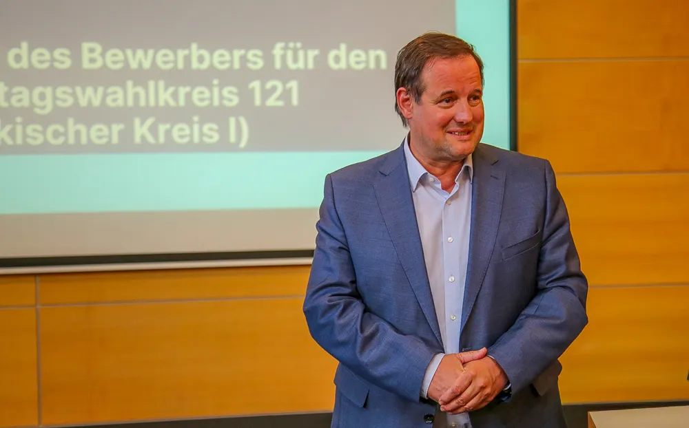 Thorsten Schick, CDU-Fraktionsvorsitzender im NRW-Landtag, bei einer Wahlveranstaltung mit der Aufschrift seines Wahlkreises im Hintergrund.