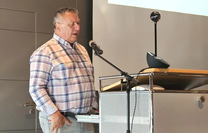 Uwe Hohlfeld spricht an einem Rednerpult mit Mikrofon.