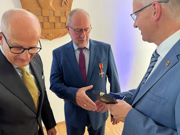 Wolfgang Vöpel erhält das Verdienstkreuz der Bundesrepublik Deutschland in einer blauen Schatulle.