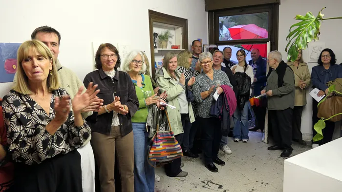 Eine Gruppe von Gästen applaudiert bei der Vernissage der Ausstellung „Zeitmangelwesen“ in der Werkstatt Plettenberg.