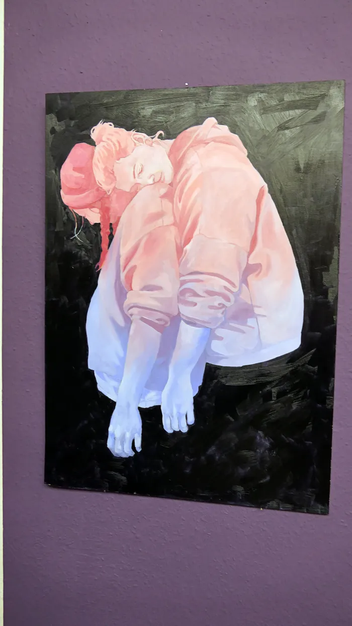 Gemälde einer in sich gekrümmten Person in rosa und hellblauer Kleidung vor dunklem Hintergrund.