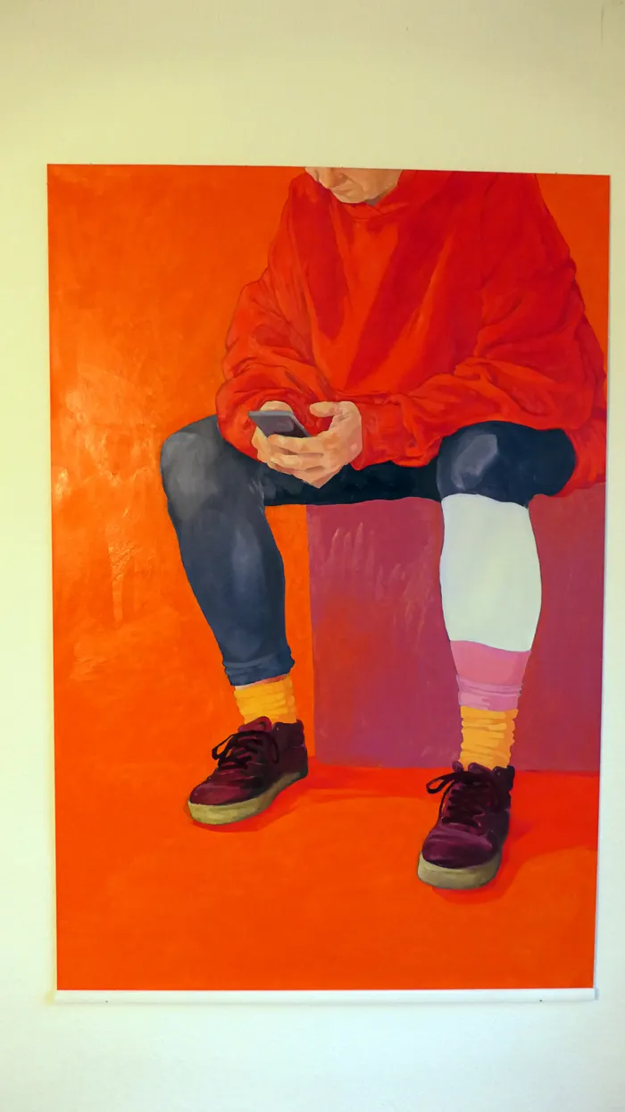 Gemälde einer sitzenden Person in rotem Hoodie, die ein Smartphone benutzt, vor einem leuchtend orangefarbenen Hintergrund.