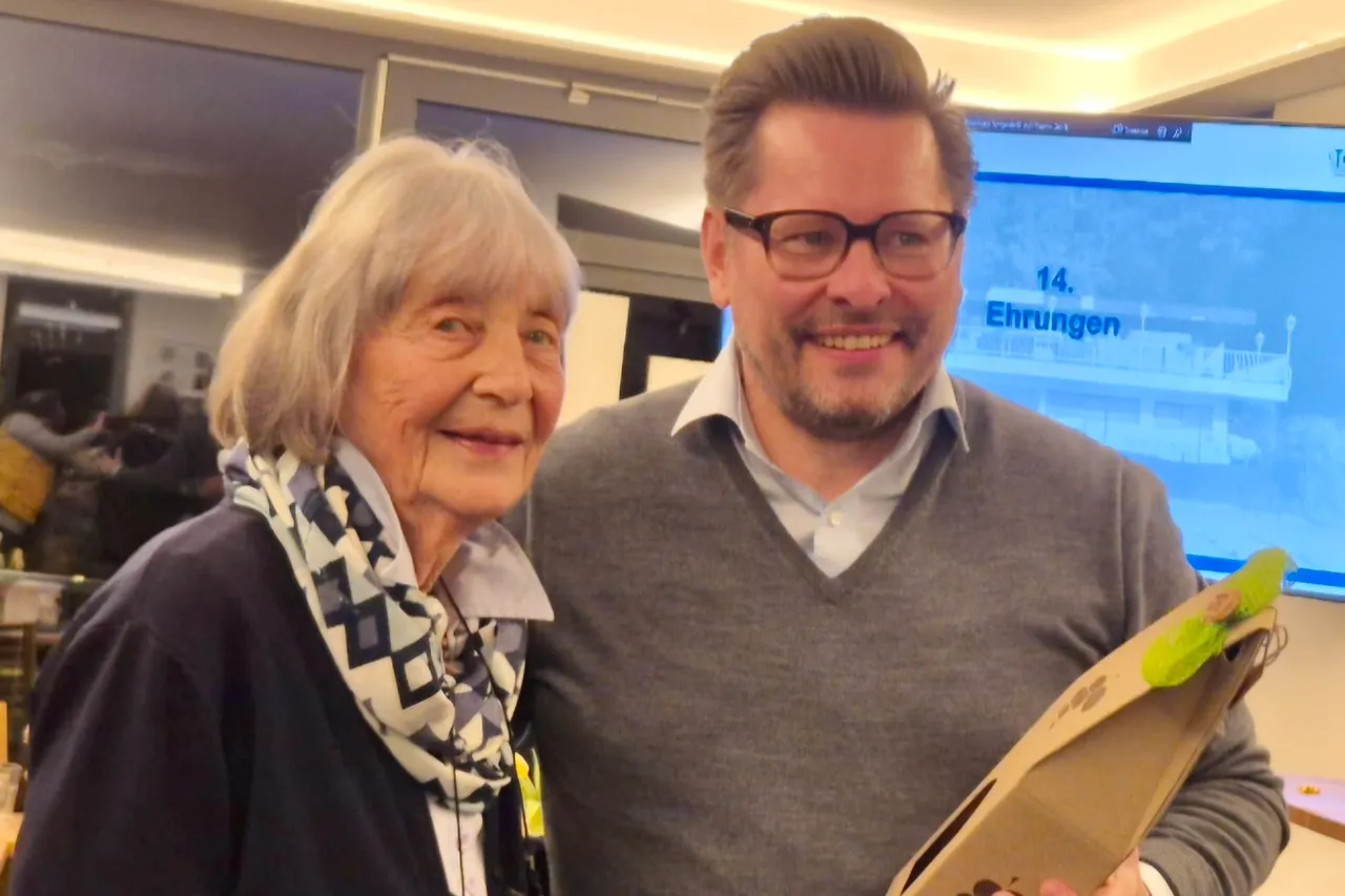 Gerhild Gladisch und Tobias Löhr posieren lächelnd bei der Jahreshauptversammlung des TC Halver. Im Hintergrund ist eine Präsentation mit der Aufschrift „14. Ehrungen“ zu sehen.