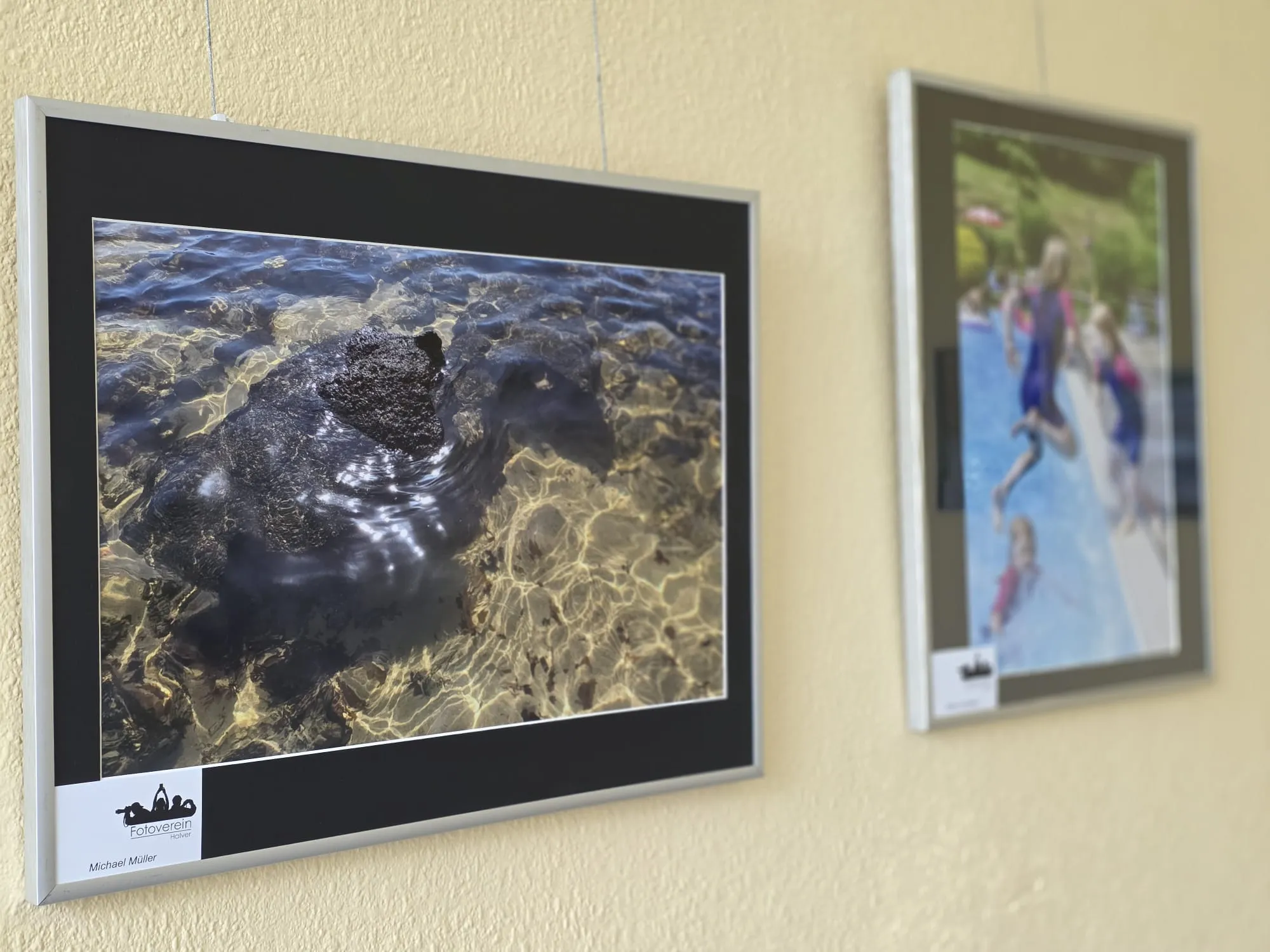 Abstrakte Aufnahme von Wasser, das über Felsen fließt und Lichtreflexe erzeugt, ausgestellt im Fotoclub Halver.