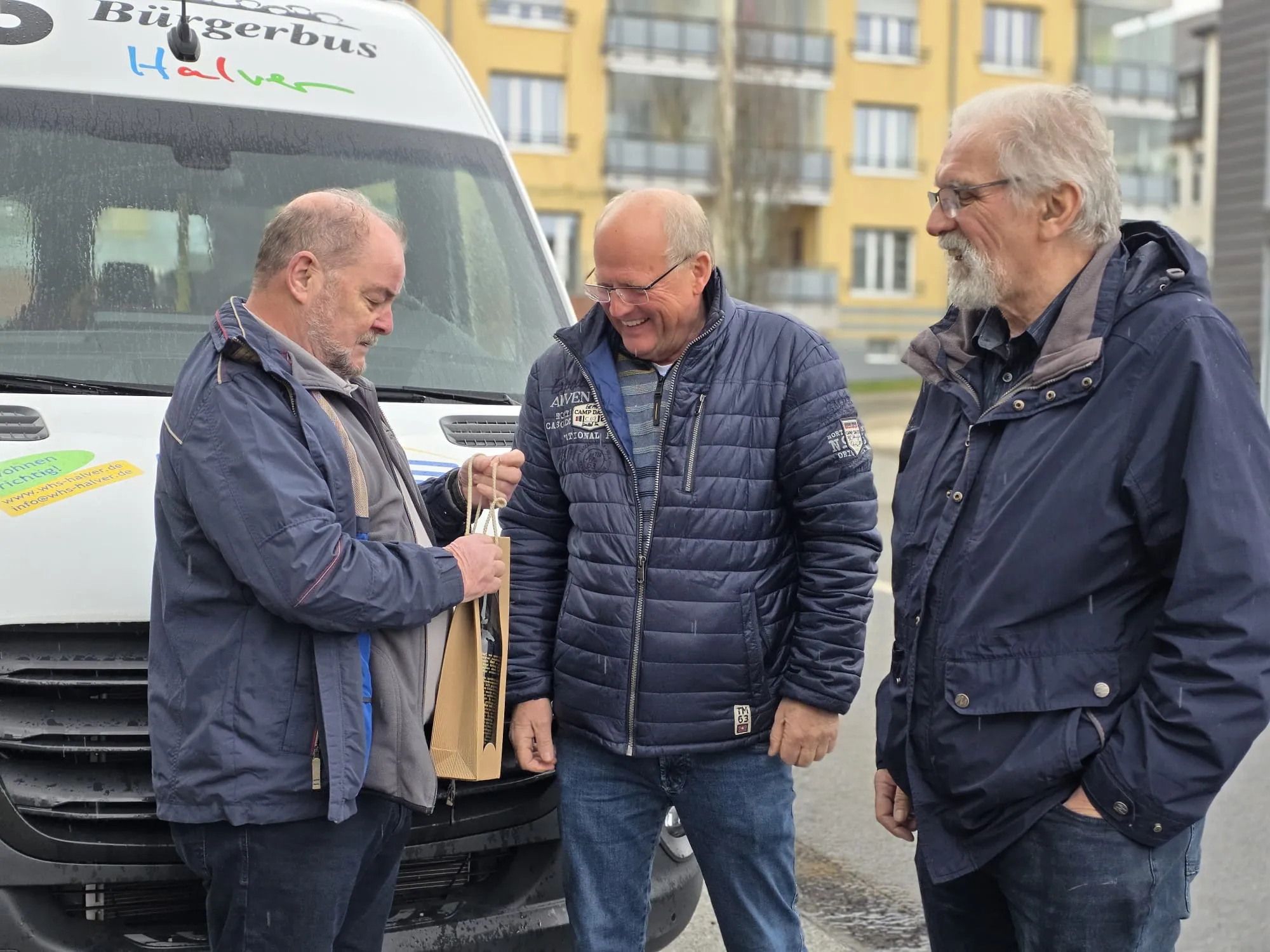 Drei Männer stehen vor einem weißen Kleinbus mit der Aufschrift „Bürgerbus Halver“ und unterhalten sich. Von links sind Klaus-Peter Viebahn, Jürgen Gottemeier und Richard Raatz zu sehen.