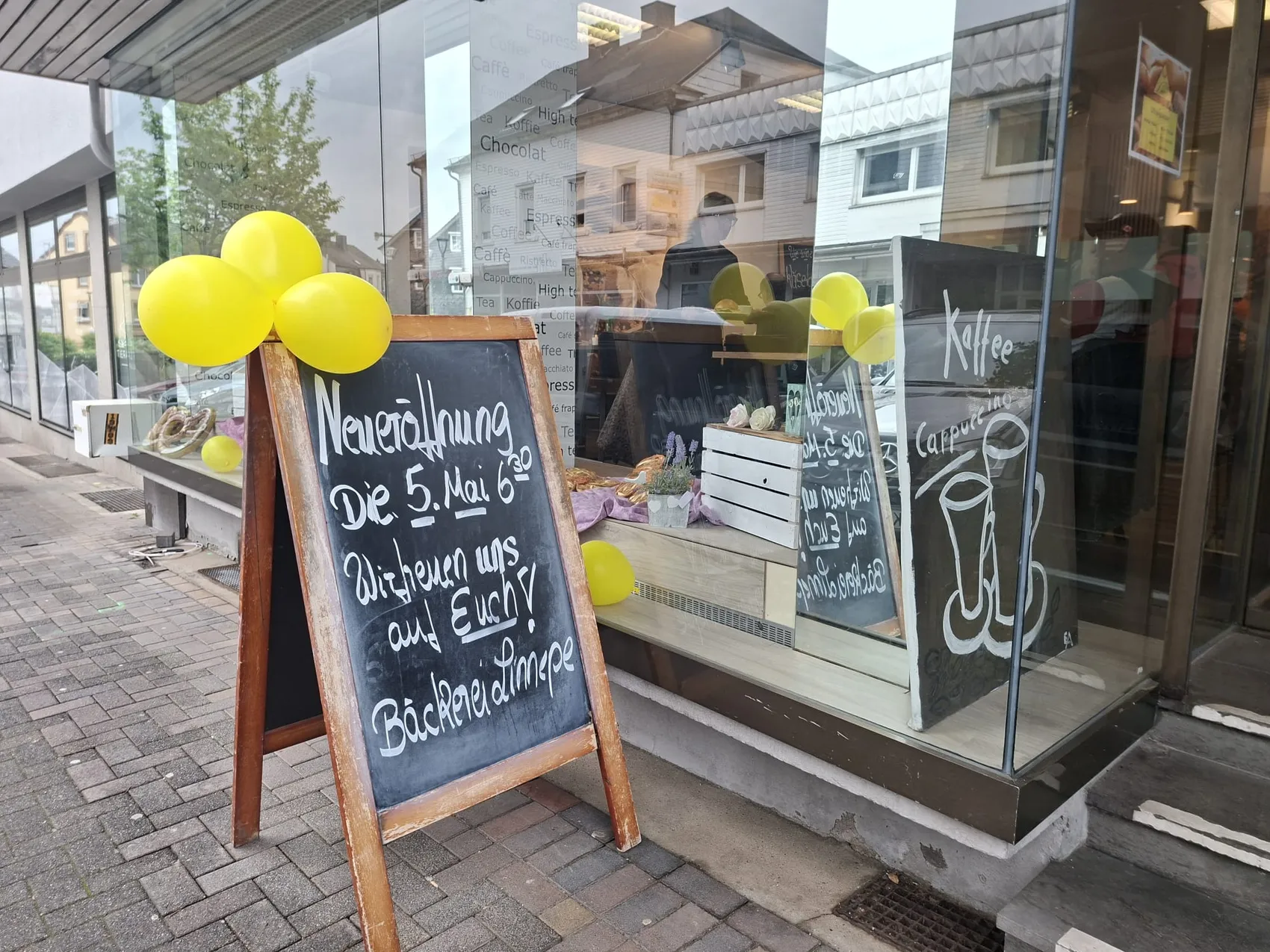 Gelbe Luftballons und ein schwarzes Schild kündigen die Neueröffnung der Café-Bäckerei-Konditorei Linnepe in der Frankfurter Straße an.
