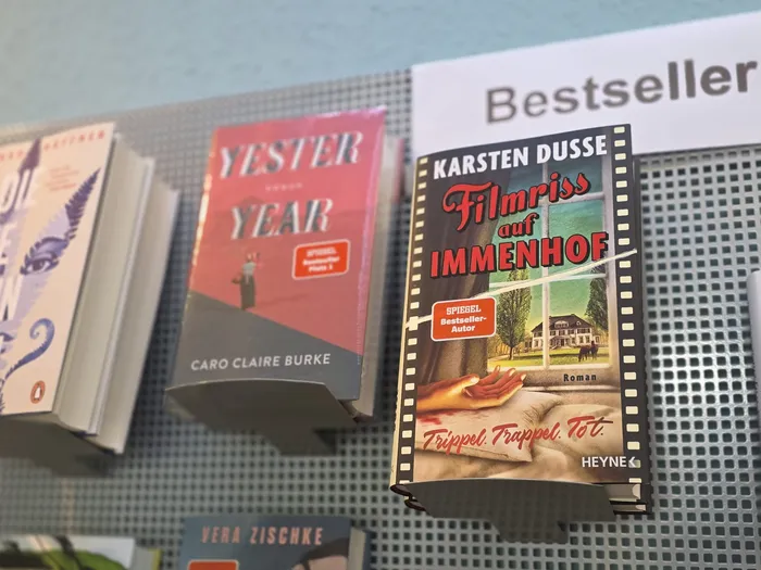 Auswahl an Büchern, darunter „Yester Year“ und „Filmriss auf Immenhof“, an einer Lochwand unter einem „Bestseller“-Schild.