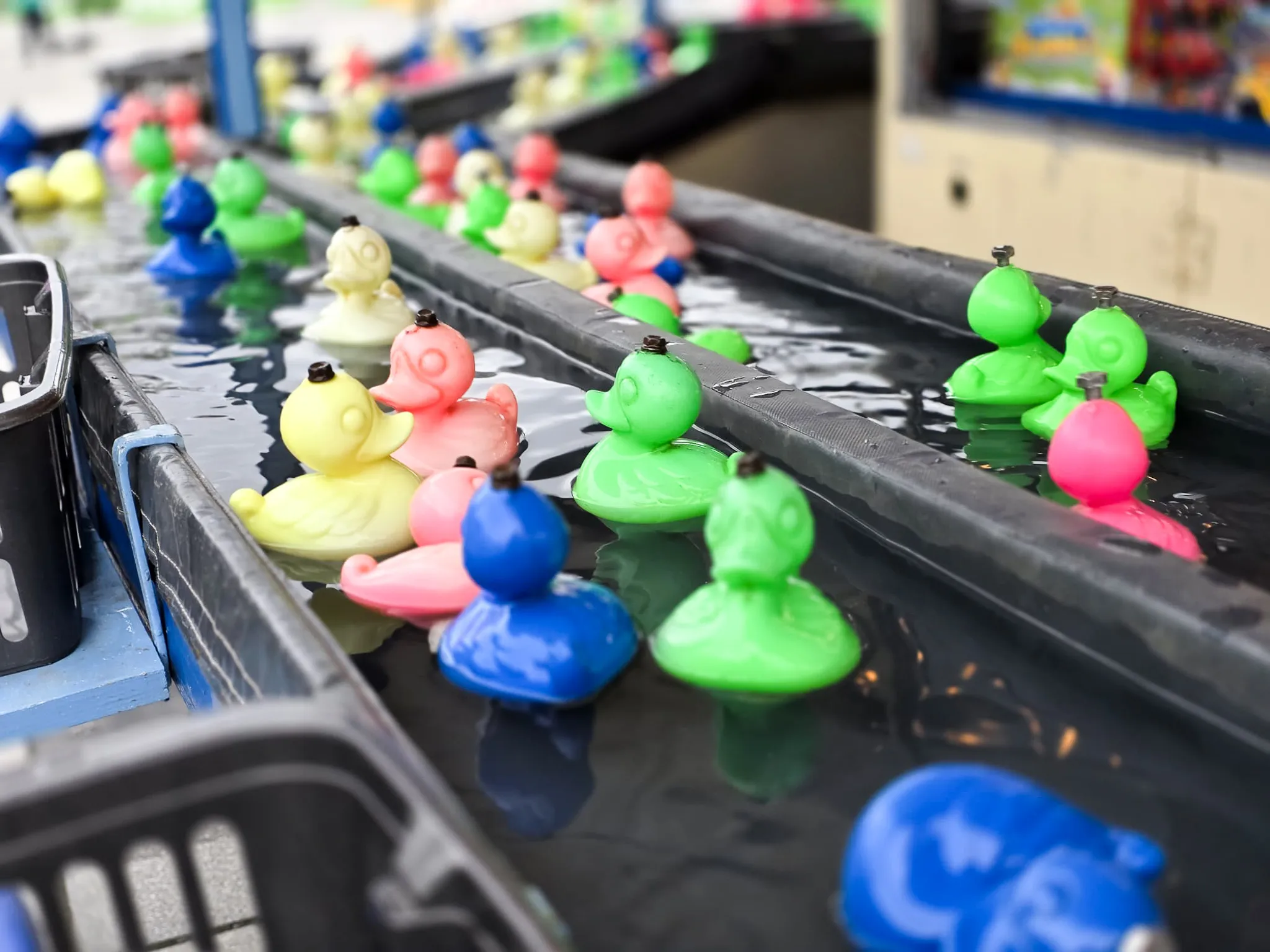 Bunte Gummienten schwimmen in einer schmalen Wasserbahn auf der Osterkirmes in Meinerzhagen.