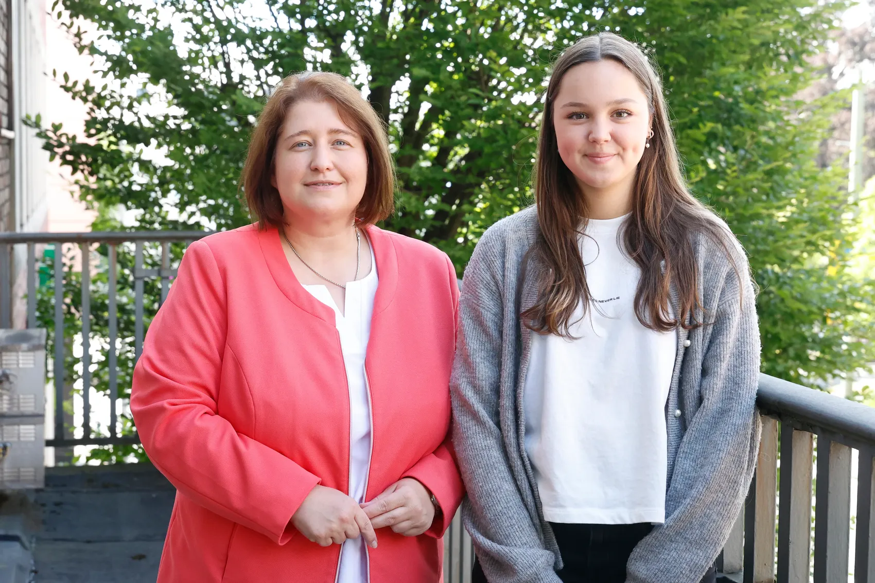 Zwei Frauen, Bettina Lugk und Pia Krämer, stehen nebeneinander vor einer Metallbrüstung. Bettina Lugk trägt eine rote Jacke, Pia Krämer einen grauen Cardigan.