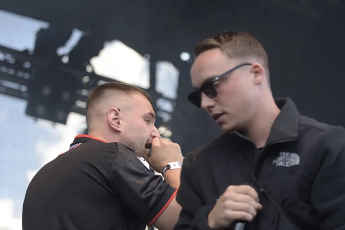 Zwei Männer auf der Collabo Stage beim Bautz 2026; einer trägt ein schwarzes Shirt mit roten Akzenten, der andere eine schwarze Jacke und eine Sonnenbrille.