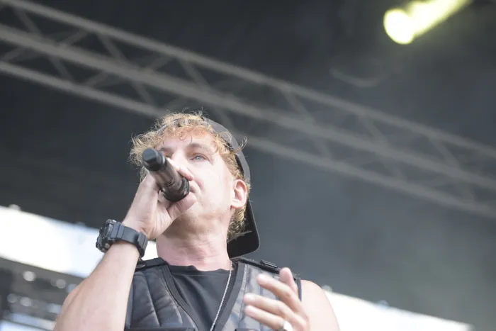 Ein Mann mit lockigem Haar und schwarzer Kappe singt in ein Mikrofon auf der Junior Carl Collabo Stage beim Bautz 2026.