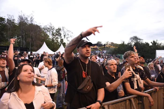 Ein Mann mit schwarzer Kappe zeigt in einer Menschenmenge auf der Collabo Stage nach vorne.