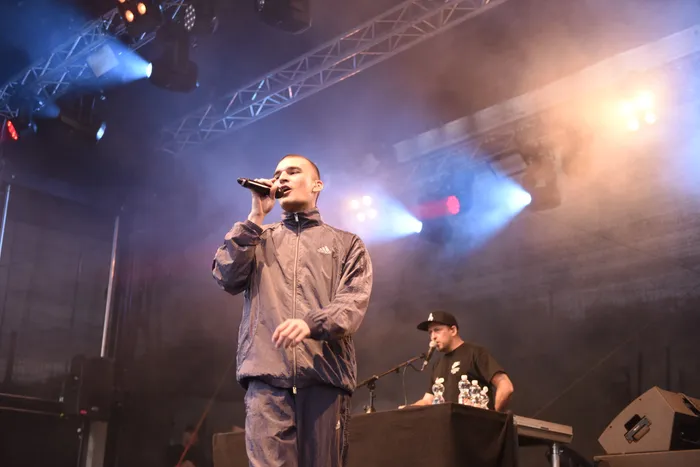 Hexer singt auf einer Bühne mit Scheinwerfern und Nebel.