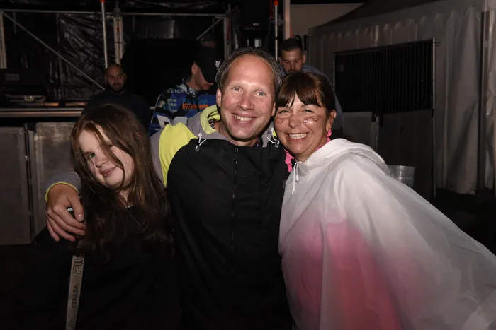 Ein Mann, ein Mädchen und eine Frau mit Gesichtsbemalung lächeln gemeinsam bei der Collabo Stage.