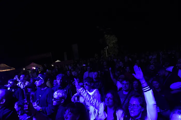 Eine Menschenmenge bei einem nächtlichen Konzert, beleuchtet durch blaues Licht.