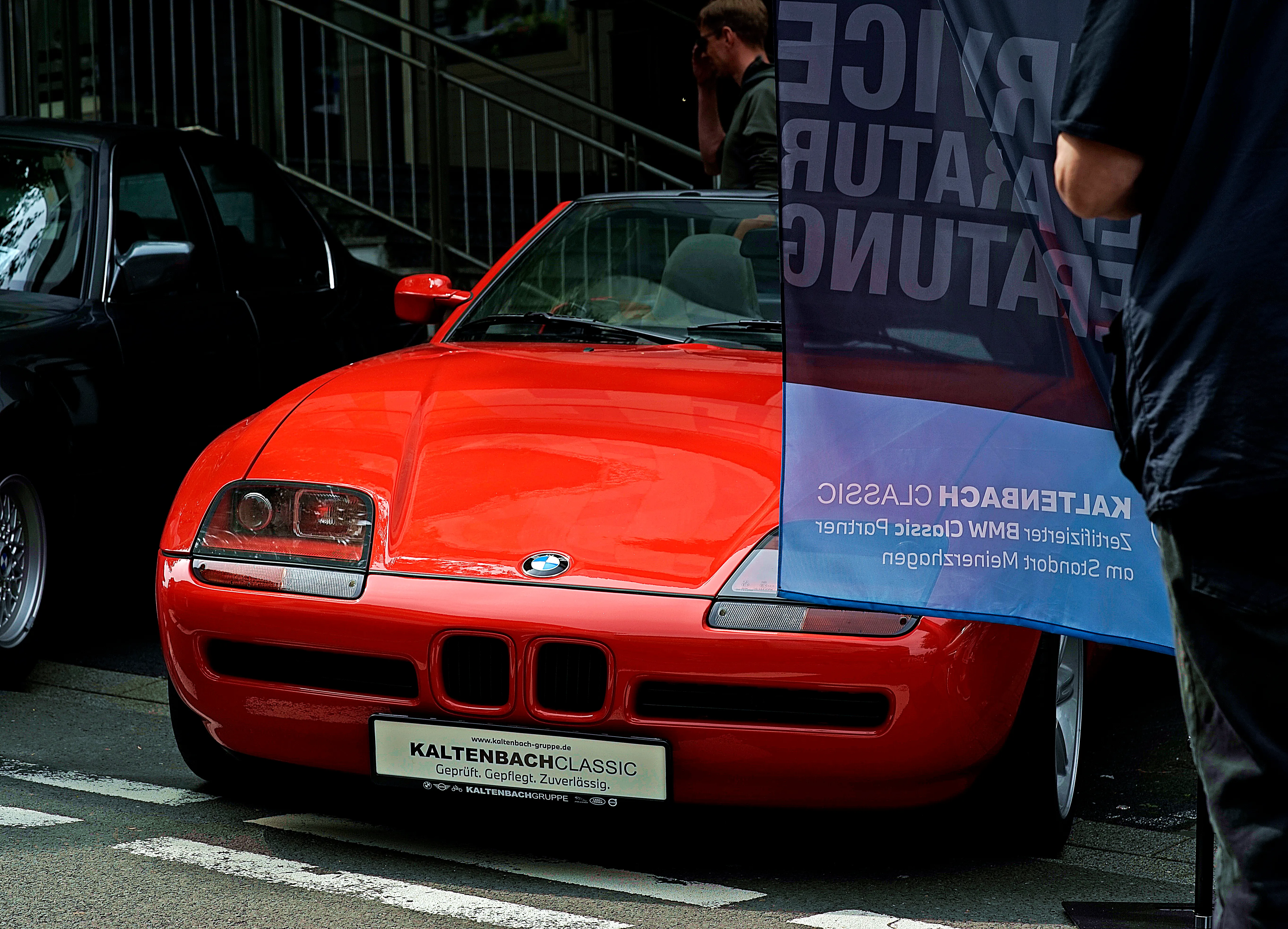 Roter BMW Z3 steht vor einem Banner mit der Aufschrift „Kaltenbach Classic“ auf einem Stadtplatz.