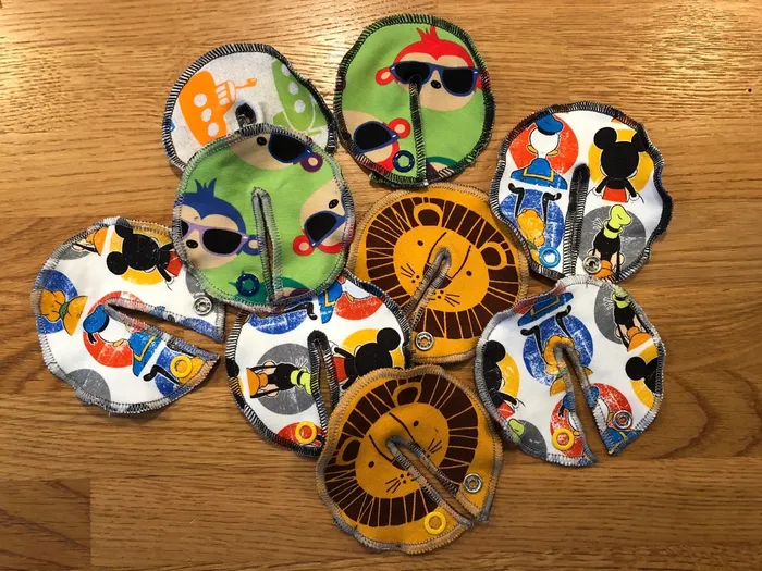 Mehrere runde Sondenpads mit Tiermotiven liegen übereinander auf einem Holztisch.