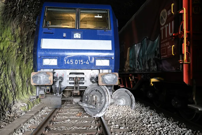 Blaue Lokomotive ist im Baukloh-Tunnel entgleist und steht schräg auf den Gleisen, daneben ein Güterwagen.