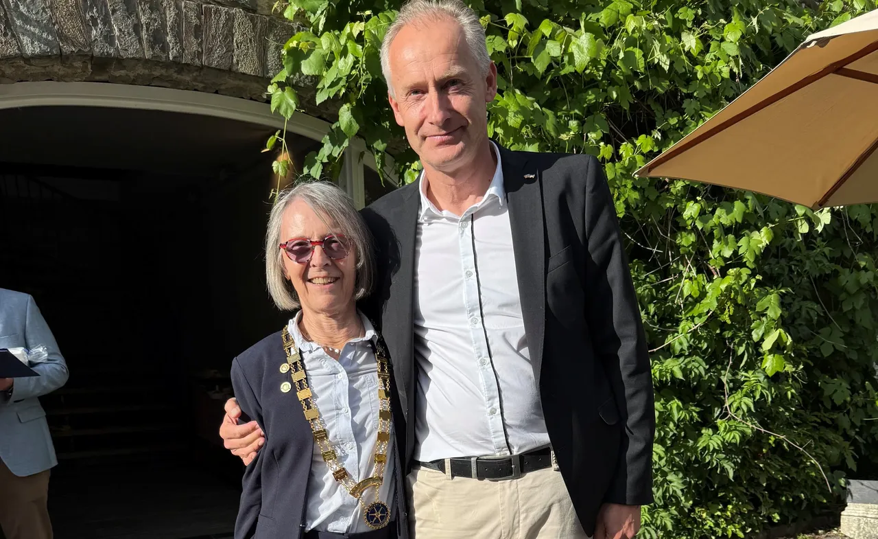 Bettina vom Brocke und Stefan Hautmann stehen lächelnd nebeneinander vor einer grünen Hecke. Bettina vom Brocke trägt eine goldene Amtskette.