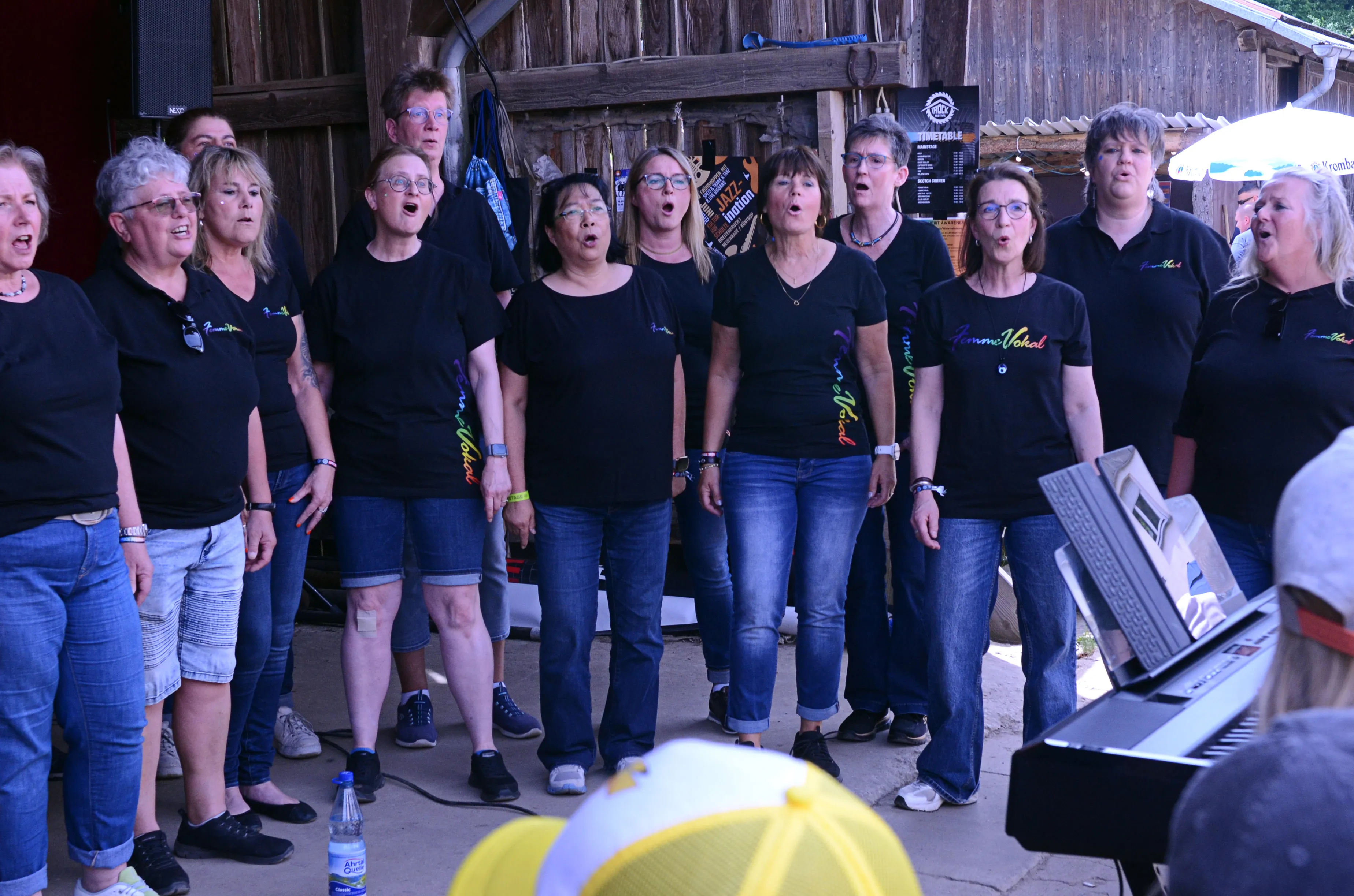 Chor „Femme Vokal“ singt auf der Bühne des I-Rock Festivals in Plettenberg. Die Mitglieder tragen schwarze T-Shirts mit dem Schriftzug des Chors.