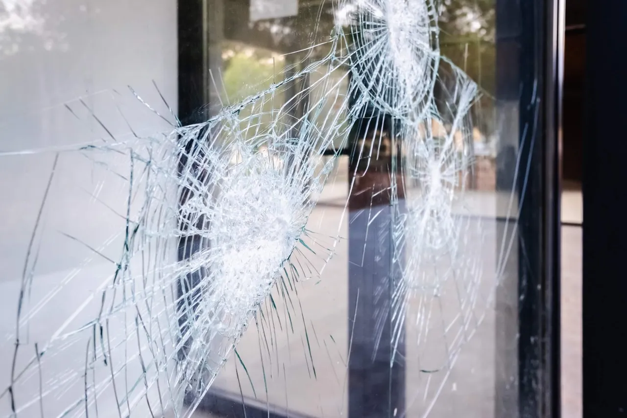 Eine zerbrochene Glasscheibe mit einem großflächigen, sternförmigen Rissmuster.