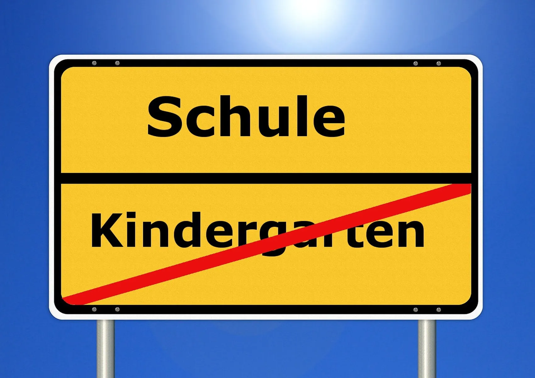 Gelbes Hinweisschild mit der Aufschrift „Schule“ und dem durchgestrichenen Wort „Kindergarten“.