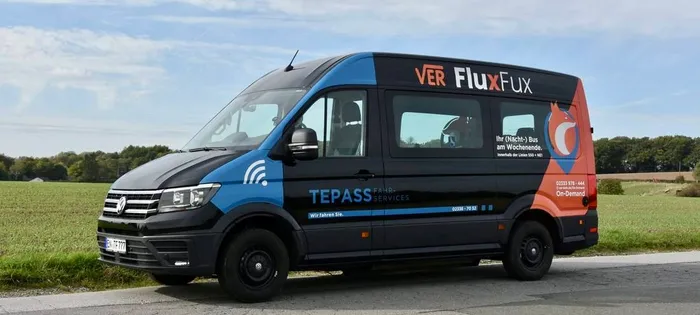 Ein dunkelblauer und hellblauer Kleinbus mit dem Aufdruck 